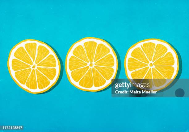 ilustrações, clipart, desenhos animados e ícones de vibrant yellow lemon slices against blue background - cru