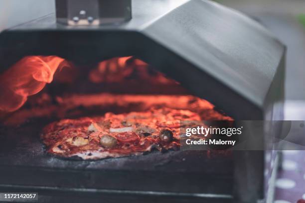 pizza being prepared in a outdoor wood fired pizza oven. - pizzaugn bildbanksfoton och bilder