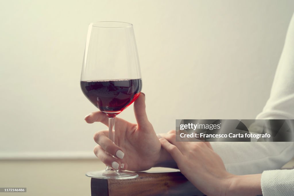 Woman holding glass of red wine