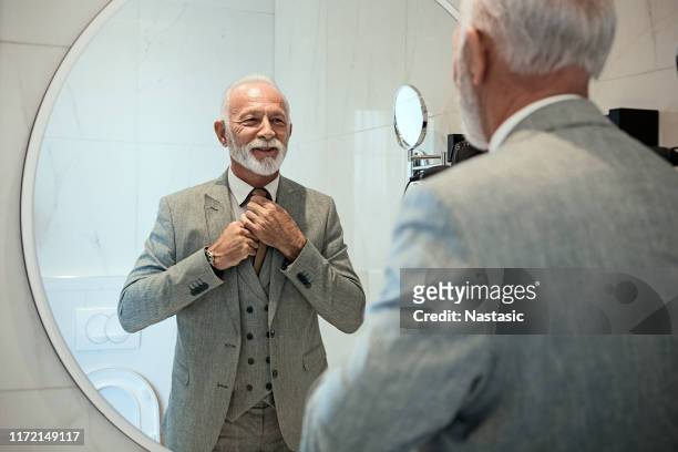 businessman dressing up in bathroom - man tying tie stock pictures, royalty-free photos & images