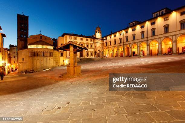 Romanesque apse of Santa Maria della Pieve, facade of Palazzo di Fraternita and Palazzo delle Logge, Piazza Grande, Arezzo, Tuscany, Italy.