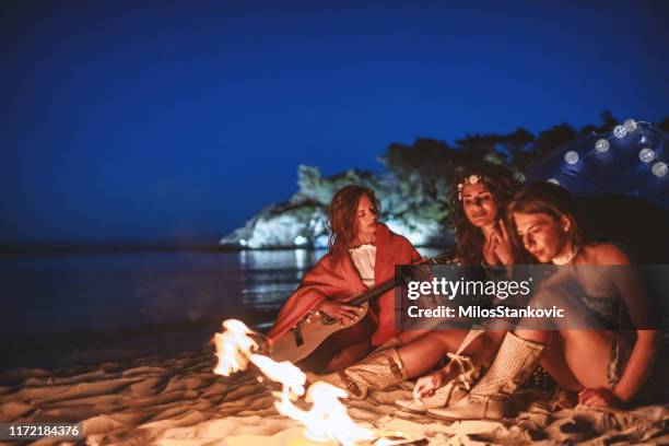 friends enjoy by the campfire at the beach - log fire stock pictures, royalty-free photos & images