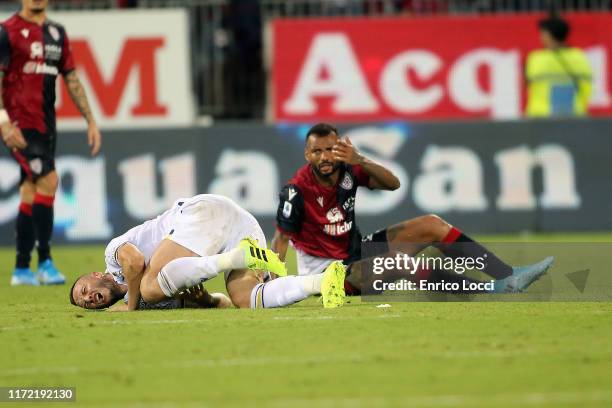 Fabio Pisacane of Cagliari and a player of Verona injured during the Serie A match between Cagliari Calcio and Hellas Verona at Sardegna Arena on...