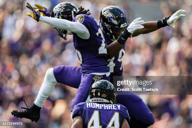 Maurice Canady of the Baltimore Ravens celebrates with Chris Board and Marlon Humphrey after intercepting a pass against the Cleveland Browns during...