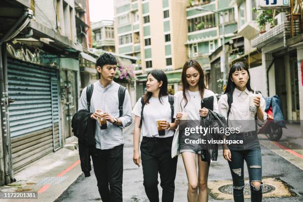 young students talking while walking on road - chinese friends stock pictures, royalty-free photos & images
