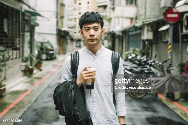 retrato de un joven estudiante con taza de café en la ciudad - taiwanés fotografías e imágenes de stock