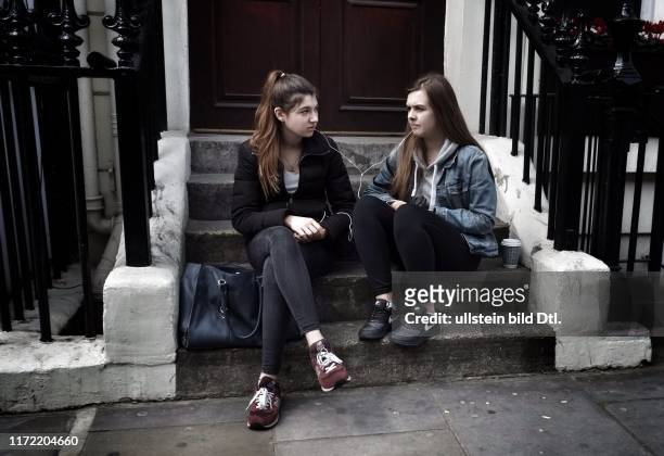 Westrminster Wahlen - Unterhauswahlen in Großbritannien - London - Touristinnen teilen Musik - Mädchen sitzen auf einer Treppe und haben nur einen...