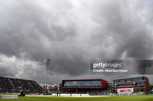 General view of Old Trafford as the grounds staff attempts to clear the covers of water during Day One of the 4th Specsavers Ashes Test between...