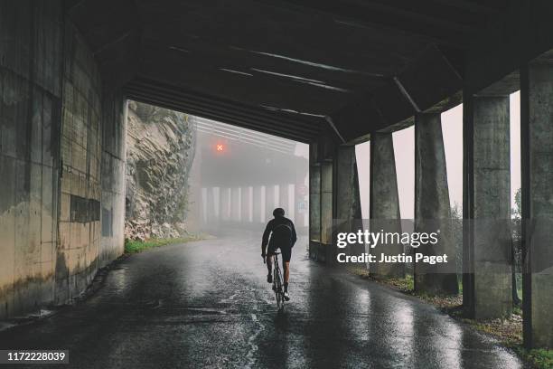 cyclist in tunnel on col de la ramaz - bike rain fotografías e imágenes de stock