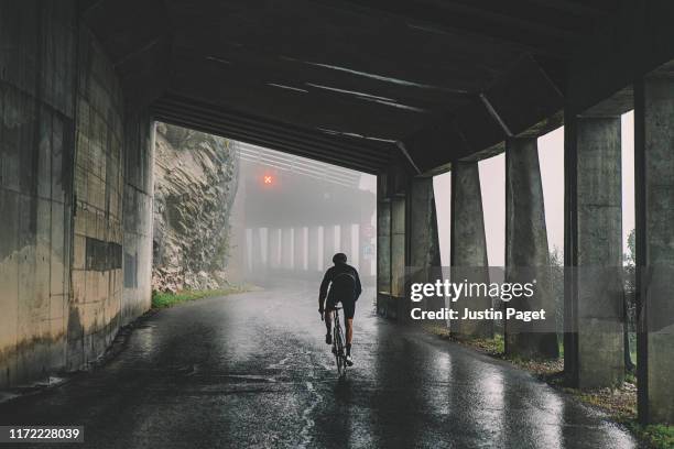 cyclist in tunnel on col de la ramaz - racefiets stockfoto's en -beelden