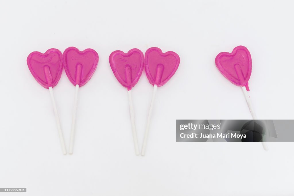 Couples of heart-shaped lollipops.  But there is one without a partner