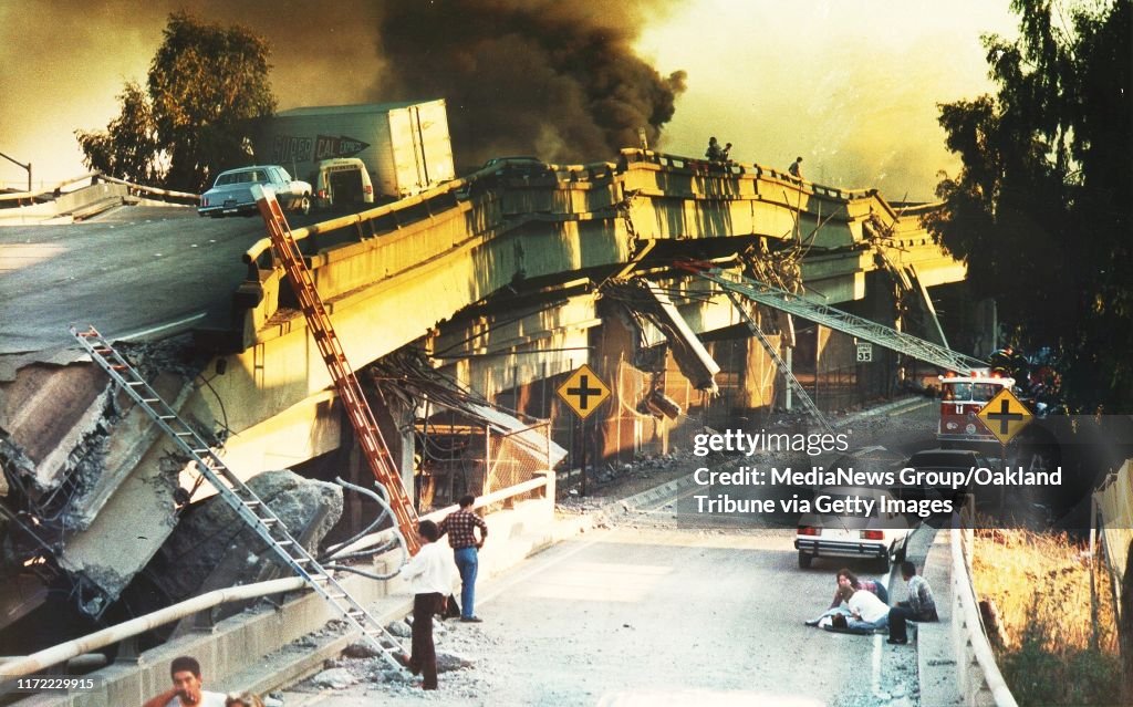 Oakland, CA October 17, 1989: Two people, lower right, comfort an injured motorist after he was pulled from the collapsed wreckage of the Cypress Freeway.The double-decked structure crumpled in the 7.0 Richter scale earthquake that shook Northern Californ