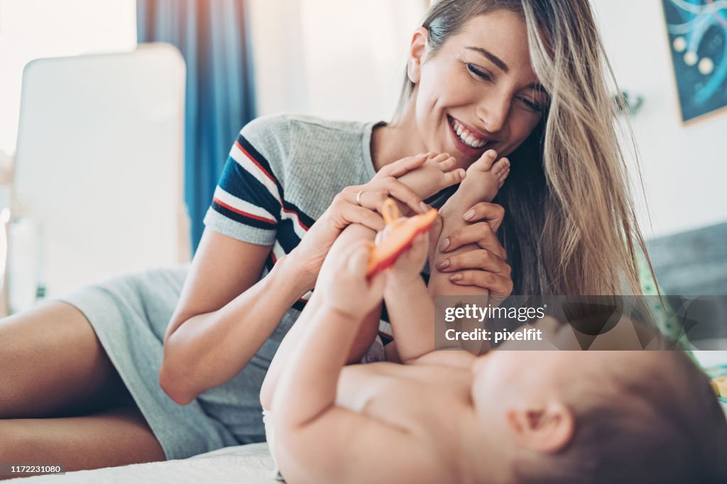 Young mother playing with her baby at home