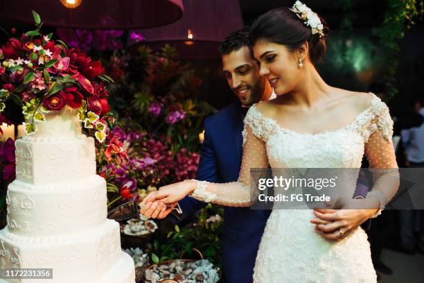 newlyweds snijden bruidstaart - wedding cake cutting stockfoto's en -beelden