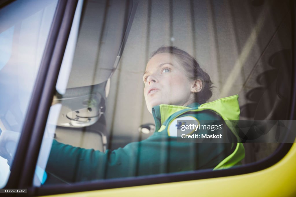 Thoughtful mid adult paramedic sitting in ambulance