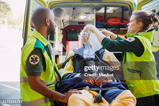 Male and female paramedics treating businessman with CPR outside ambulance Male and female paramedics treating businessman with CPR outside ambulance