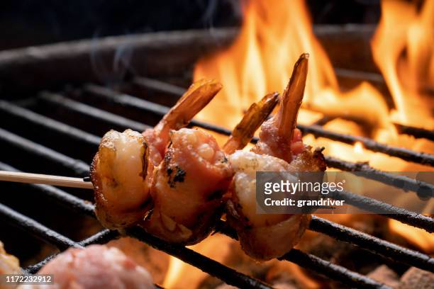high fat, ketogenic bacon wrapped jumbo shrimp on a fiery old-fashioned charcoal grill - bbq shrimp stock pictures, royalty-free photos & images