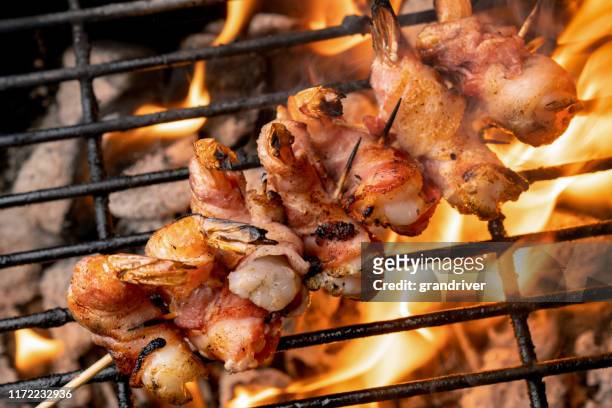 high fat, ketogenic bacon wrapped jumbo shrimp on a fiery old-fashioned charcoal grill - broiling stock pictures, royalty-free photos & images