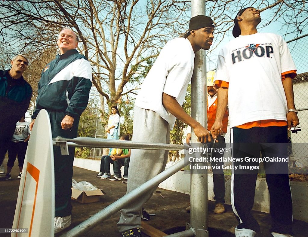 Oakland, CA January 29, 2000: Warriors head coach Garry St. Jean (left) stands by as players Antawn Jamison (center) and Sam Jacobson work on installing a a basketball net for the finishing touches on renovating Rainbow Park into All-Star Park in East Oak
