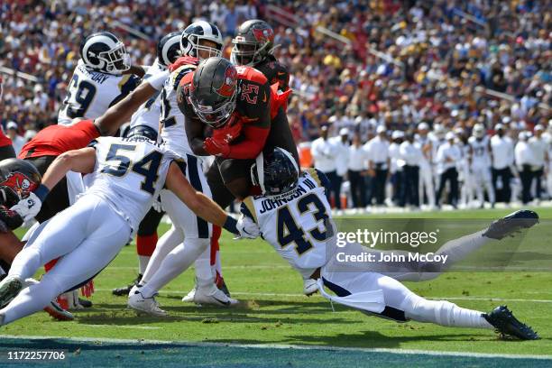 Peyton Barber of the Tampa Bay Buccaneers get past Bryce Hager of the Los Angeles Rams and John Johnson to score in the first quarter at Los Angeles...