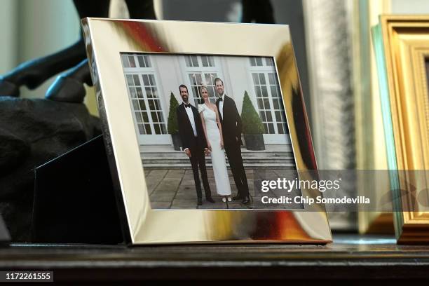 Framed photograph of U.S. President Donald Trump's children - Donald Trump Jr., Ivanka Trump and Eric Trump, - sits on a table behind the president's...