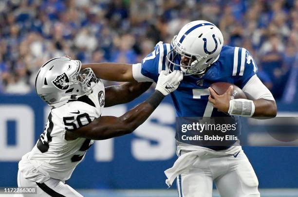 Jacoby Brissett of the Indianapolis Colts stiff arms Nicholas Morrow of the Oakland Raiders as he is tackled by his face-masksk in the fourth quarter...
