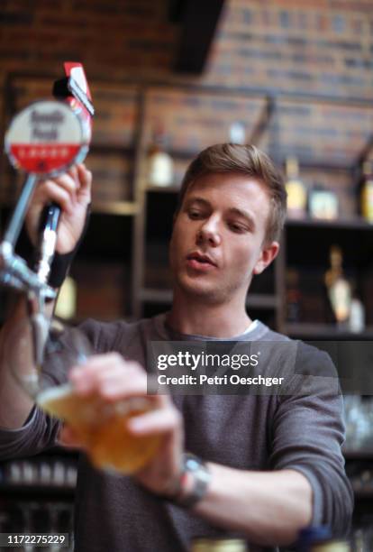 barman pouring a beer. - pint glass stock pictures, royalty-free photos & images