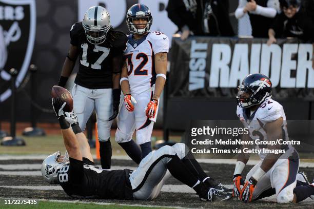 Oakland Raiders' Nick Kasa reacts after scoring a touchdown in front of Denver Broncos' Wesley Woodyard in the fourth quarter of their game at O.co...