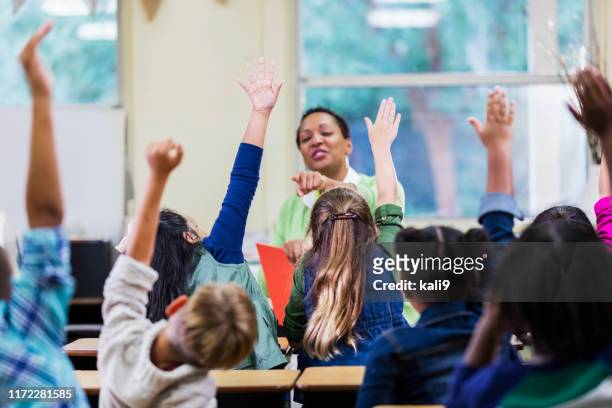 teacher and students in elementary school classroom - arms raised stock pictures, royalty-free photos & images