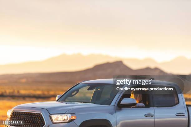 pickup-truck auf western usa roads highways desert and mountains mit reifen erwachsenen fahrergeparkt, um den sonnenaufgang in der nähe von moab utah zu sehen und zu genießen - pick up truck stock-fotos und bilder