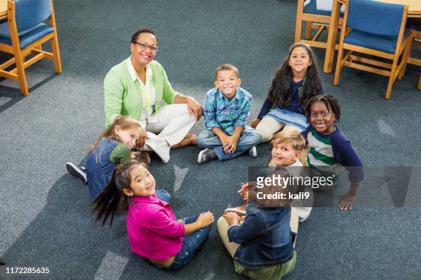 insegnante, studenti delle scuole elementari seduti in cerchio - bambini seduti in cerchio foto e immagini stock