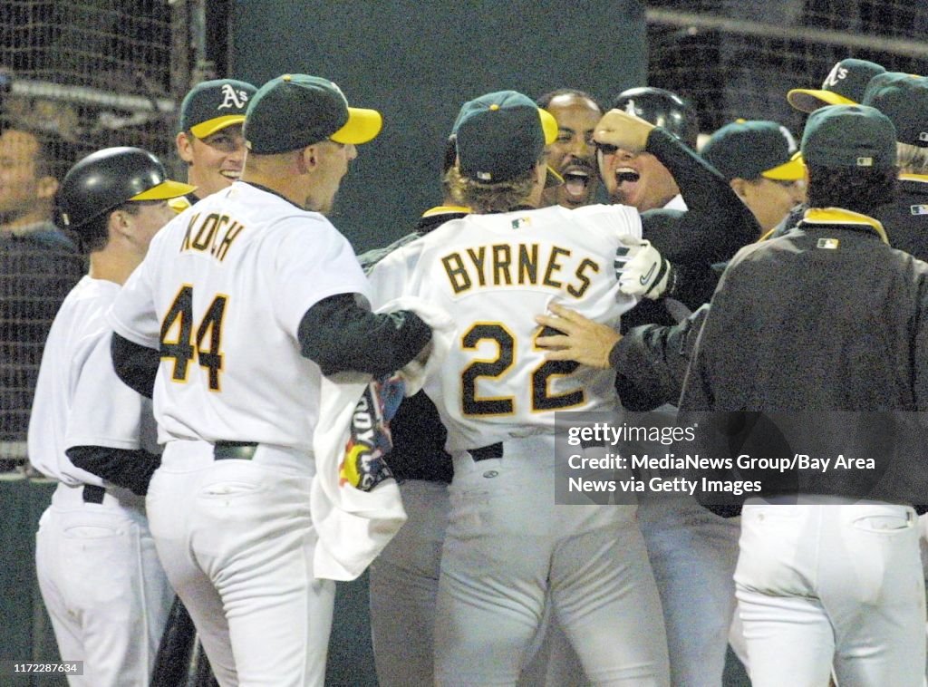 Nick Lammers/staff 9/5/02 Tribune Sports Oakland Athletics' Scott Hatteberg mobbed by teammates at home plate after hitting the game-winning home run in the ninth inning to beat the Kansas City Royals 12-11, Wednesday, Sept. 4, 2002 in Oakland, Calif