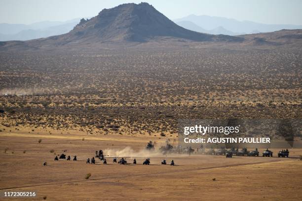 Attendees march on their atv vehicles during a car cruise at Wasteland Weekend festival at the Mojave desert in Edwards, California on September 28,...