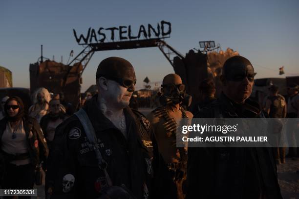 Attendees return to their campgroud after a car cruise during Wasteland Weekend festival at the Mojave desert in Edwards, California on September 28,...