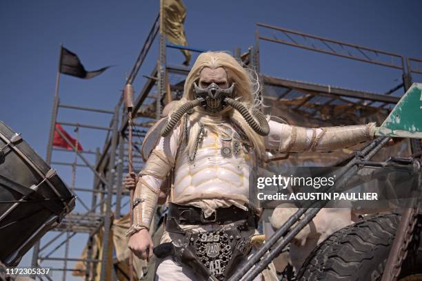 Man in a "Mad Max" Immortan Joe costume poses for pictures during Wasteland Weekend festival at the Mojave desert in Edwards, California on September...