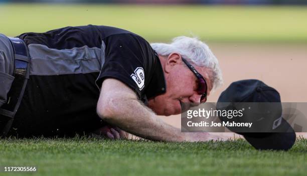 First base umpire Brian Gorman hits the ground after a collision with Yonathan Daza of the Colorado Rockies in the 13th of a game against the...