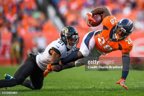 Royce Freeman of the Denver Broncos is tackled by A.J. Bouye of the Jacksonville Jaguars in the fourth quarter of a game at Empower Field at Mile...