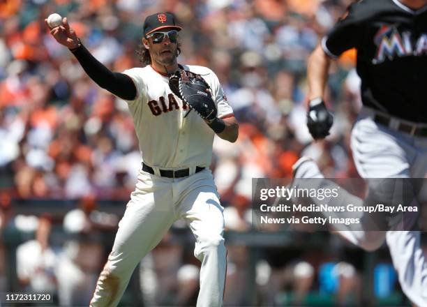 San Francisco Giants' Michael Morse throws to first base for an out on a bunt by Miami Marlins' starting pitcher Jacob Turner in the third inning at...