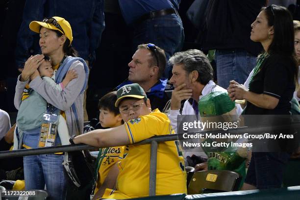 Oakland A's fan are dejected after Oakland Athletics' Josh Reddick strikes out against the Detroit Tigers to end Game 1 of the American League...