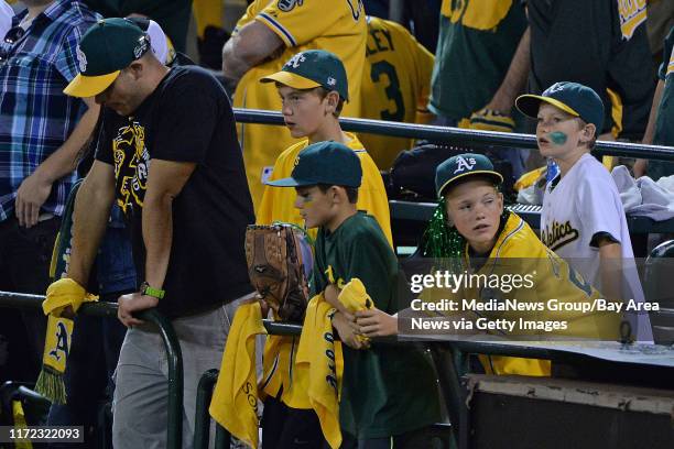 Oakland A's fan are dejected after Oakland Athletics' Josh Reddick strikes out against the Detroit Tigers to end Game 1 of the American League...