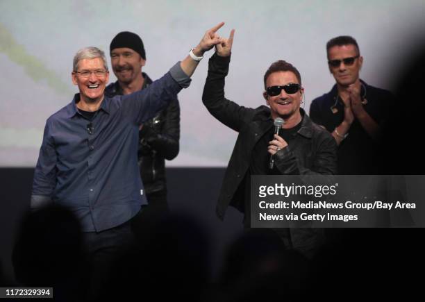 Apple CEO Tim Cook connects fingers with Bono to symbolically launch the release of U2's new album on Apple's iTunes during an Apple product release...