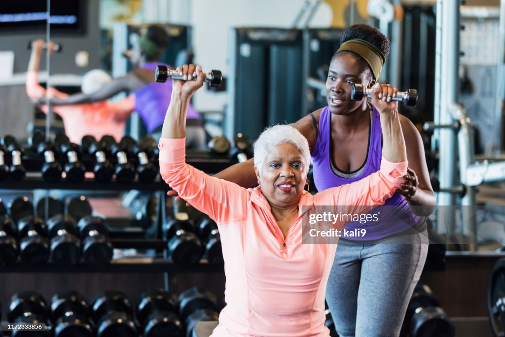 African-American fitness instructor helping senior woman