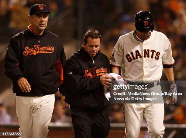 San Francisco Giants manager Bruce Bochy and trainer Dave Groeschner walk off the field with San Francisco Giants' starting pitcher Ryan Vogelsong...