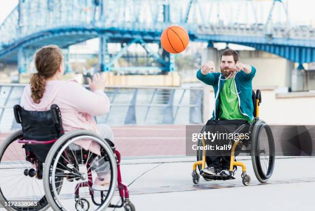 couple in wheelchairs playing basketball - passar a bola imagens e fotografias de stock