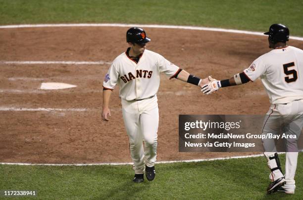 San Francisco Giants Buster Posey celebrates walk to home plate with Juan Uribe againts Texas Ranger relieved pitcher Derek Holland walked three...