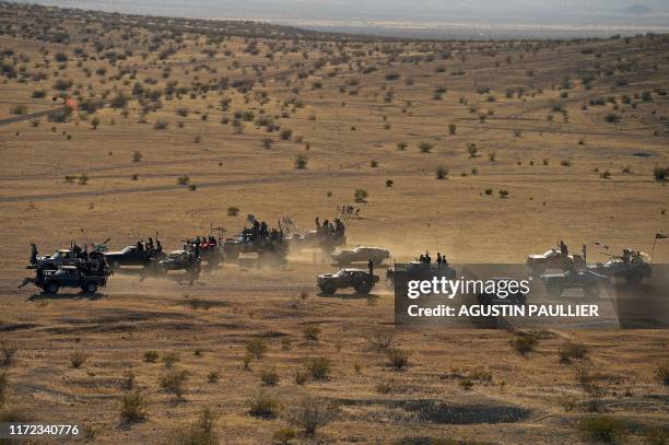 Attendees drive their atv vehicles during a car cruise at Wasteland Weekend festival at the Mojave desert in Edwards, California on September 28,...