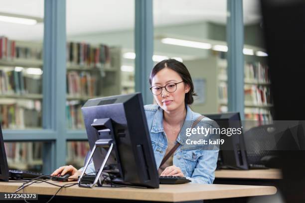 young asian woman in library using computer - public library stock pictures, royalty-free photos & images