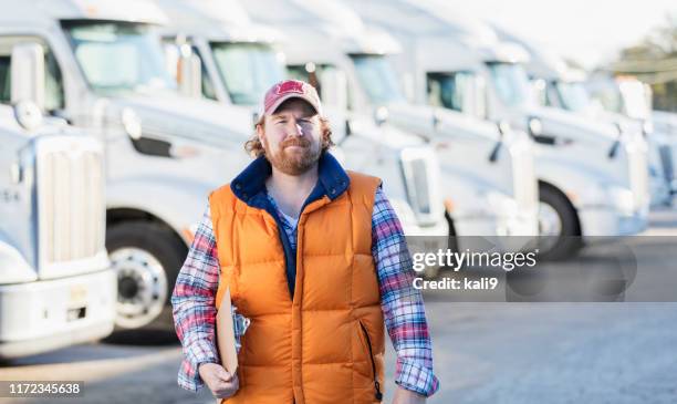 man standing in front of semi-truck fleet - white warehouse stock pictures, royalty-free photos & images