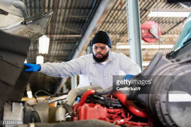 african-american mechanic repairing semi-truck - truck repair stock pictures, royalty-free photos & images
