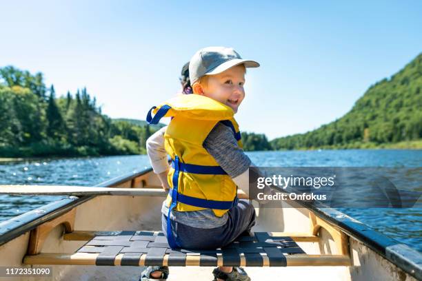 little redhead boy canoeing avec sa famille au parc national de la jacques cartier, québec, canada - canoë photos et images de collection